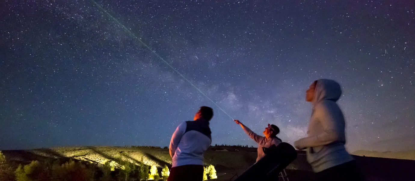 two people pointing green laser on stargazing tours in jackson